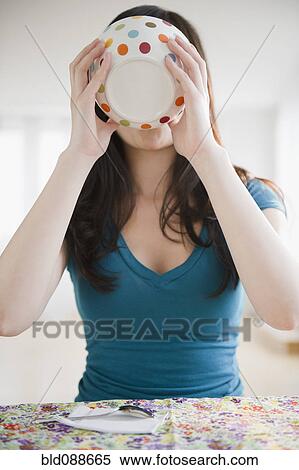 Stock Photography - Korean woman drinking from bowl. Fotosearch