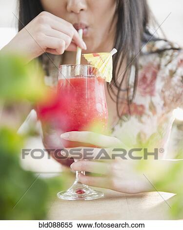 Stock Photography - Korean woman drinking tropical cocktail. Fotosearch