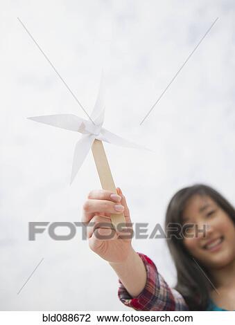 Stock Image - Korean woman holding paper pinwheel. Fotosearch