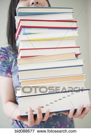 Korean woman holding stack of books View Large Photo Image Stock Photo - Korean woman holding stack of books. Fotosearch