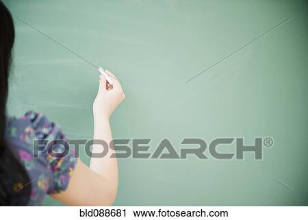 Stock Image - Korean woman writing on blackboard. Fotosearch