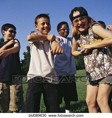 Stock Image - Laughing children playing outdoors together. Fotosearch