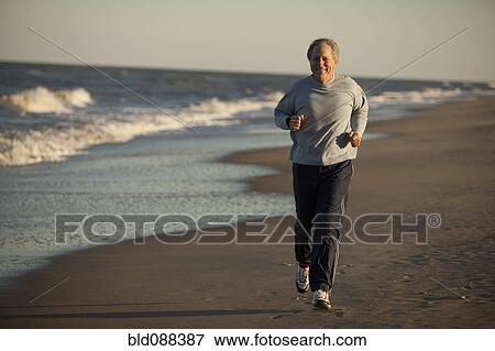 Stock Photo - Man running on beach. Fotosearch