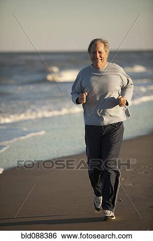 Stock Photograph - Man running on beach. Fotosearch