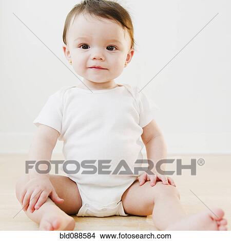 Picture - Mixed race baby sitting on floor. Fotosearch