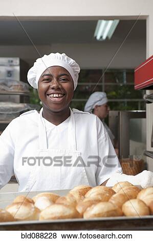 Mixed race baker working in commercial kitchen View Large Photo Image Stock Photo - Mixed race baker working in commercial kitchen. Fotosearch