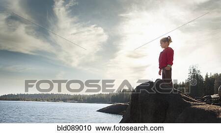Mixed race girl standing on rock near remote lake View Large Photo Image Stock Image - Mixed race girl standing on rock near remote lake. Fotosearch
