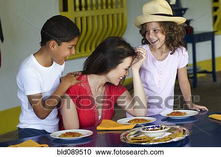 Mother and children eating dinner View Large Photo Image Stock Image - Mother and children eating dinner. Fotosearch