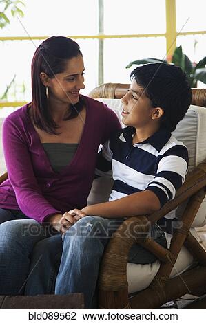 Stock Image - Mother and son talking on porch. Fotosearch