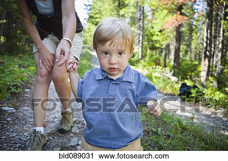 Mother and son walking on remote forest path View Large Photo Image Stock Image - Mother and son walking on remote forest path. Fotosearch