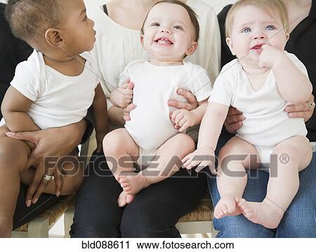 Stock Image - Mothers holding babies on their laps. Fotosearch