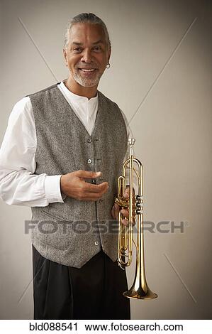 Musician holding trumpet View Large Photo Image Stock Image - Musician holding trumpet. Fotosearch