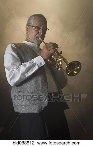 Stock Image - Musician playing trumpet on stage. Fotosearch