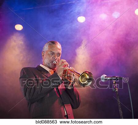 Stock Image - Musician playing trumpet on stage. Fotosearch