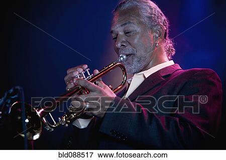 Stock Photo - Musician playing trumpet on stage. Fotosearch