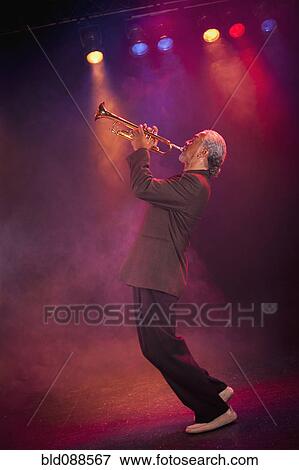 Stock Photo - Musician playing trumpet on stage. Fotosearch