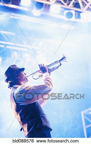 Musician playing trumpet on stage View Large Photo Image Stock Photo - Musician playing trumpet on stage. Fotosearch