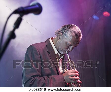 Musician playing trumpet on stage View Large Photo Image Stock Photograph - Musician playing trumpet on stage. Fotosearch