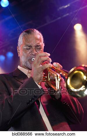 Stock Photograph - Musician playing trumpet on stage. Fotosearch