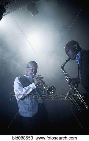 Stock Image - Musicians playing in jazz band on stage. Fotosearch