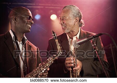 Stock Image - Musicians playing in jazz band on stage. Fotosearch
