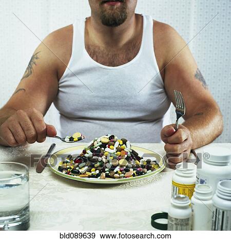 Stock Photo - Overweight man eating plate full of pills. Fotosearch