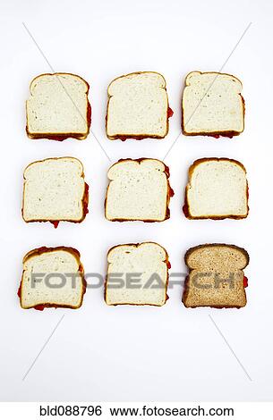 Stock Photograph - Peanut butter and jelly sandwiches, one on whole wheat bread. Fotosearch