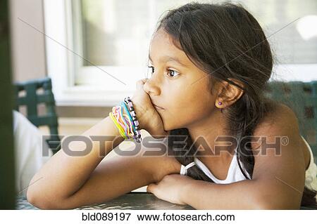 Stock Photo - Pensive Hispanic girl with head in hands. Fotosearch