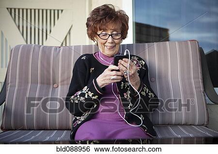 Senior Caucasian woman listening to mp3 player View Large Photo Image Stock Photograph - Senior Caucasian woman listening to mp3 player. Fotosearch