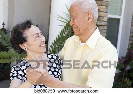 Stock Photo - Senior Chinese couple dancing outdoors. Fotosearch