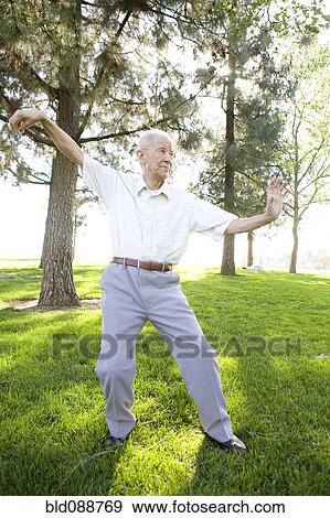 Stock Photo - Senior Chinese man doing tai chi outdoors. Fotosearch
