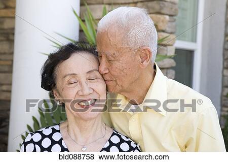 Stock Photo - Senior Chinese man kissing wife. Fotosearch
