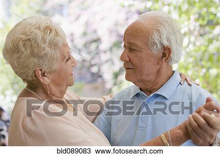Stock Image - Senior Hispanic couple dancing together. Fotosearch