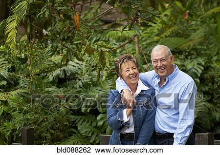 Stock Image - Senior Hispanic couple hugging outdoors. Fotosearch