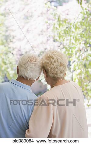 Picture - Senior Hispanic couple standing arm in arm. Fotosearch