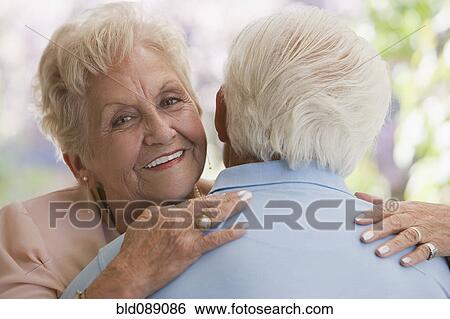 Senior Hispanic woman hugging husband View Large Photo Image Stock Photograph - Senior Hispanic woman hugging husband. Fotosearch