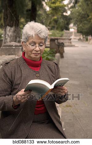 Senior Hispanic woman reading book in park View Large Photo Image Stock Image - Senior Hispanic woman reading book in park. Fotosearch