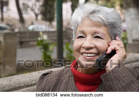 Picture - Senior Hispanic woman talking on cell phone. Fotosearch