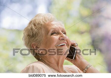 Stock Photography - Senior Hispanic woman talking on cell phone. Fotosearch