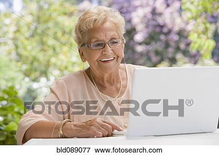 Senior Hispanic woman using laptop View Large Photo Image Stock Photo - Senior Hispanic woman using laptop. Fotosearch