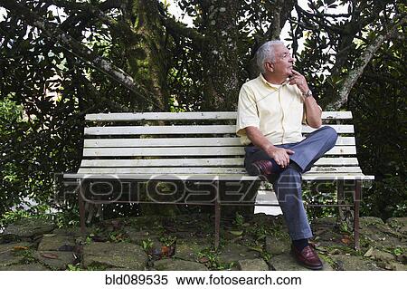 Stock Photography - Senior man sitting on park bench. Fotosearch
