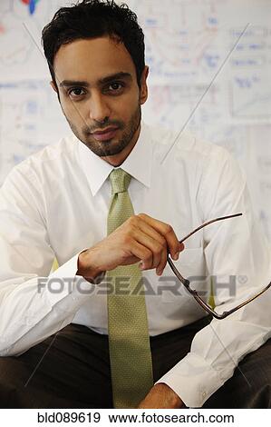 Serious businessman holding eyeglasses View Large Photo Image Stock Photo - Serious businessman holding eyeglasses. Fotosearch