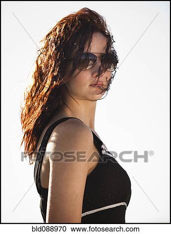 Stock Image - Serious Caucasian woman wearing sunglasses. Fotosearch