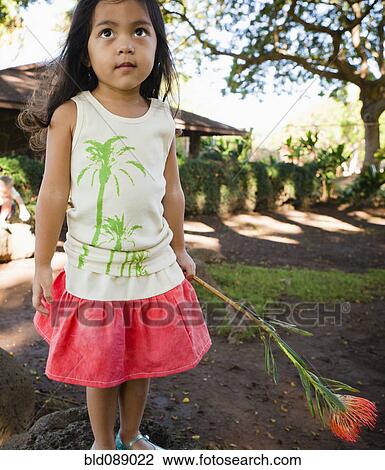 Stock Image - Serious girl holding exotic flower. Fotosearch