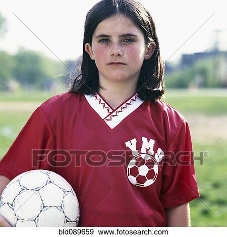 Stock Photo - Serious girl in uniform holding soccer ball. Fotosearch