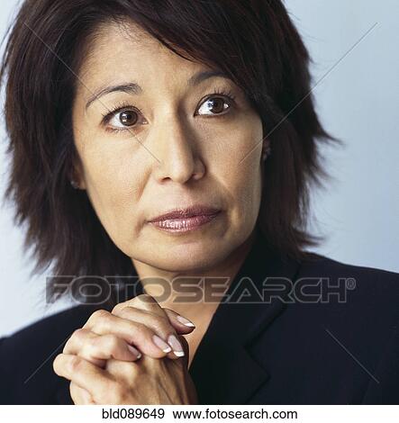 Serious mixed race businesswoman with hands clasped View Large Photo Image Stock Photo - Serious mixed race businesswoman with hands clasped. Fotosearch