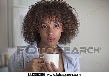 Serious mixed race woman drinking coffee View Large Photo Image Stock Photograph - Serious mixed race woman drinking coffee. Fotosearch