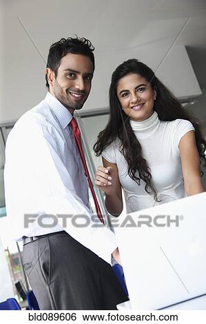 Stock Photograph - Smiling business people working together in office. Fotosearch