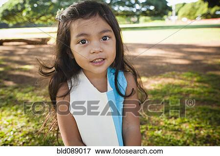 Stock Photo - Smiling girl standing outdoors. Fotosearch