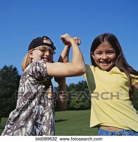 Smiling girls flexing biceps outdoors View Large Photo Image Stock Image - Smiling girls flexing biceps outdoors. Fotosearch